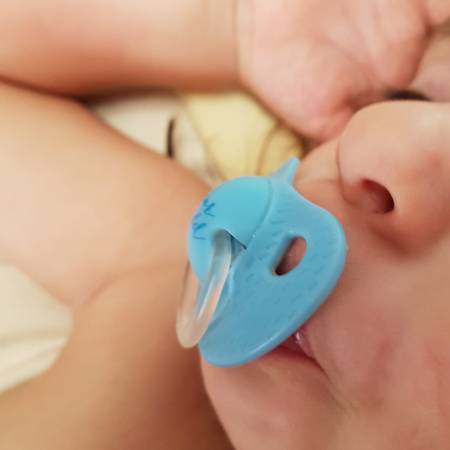 infant de 33 mesos dormint amb un xumet blau